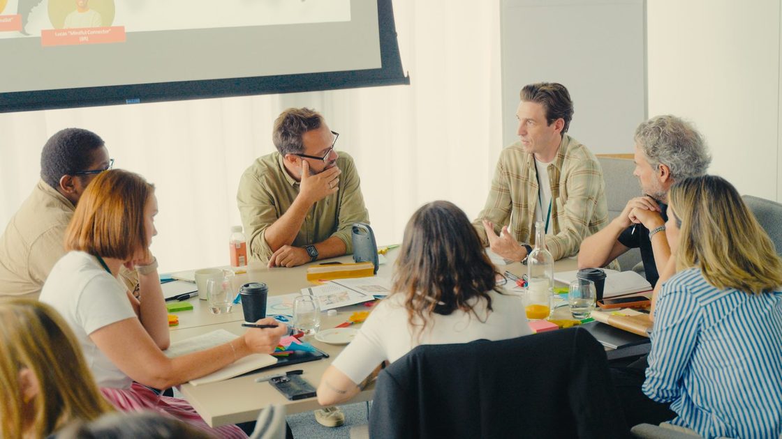 A REBORRN working session: a mixed client and REBORRN team around a table, mid-discussion.